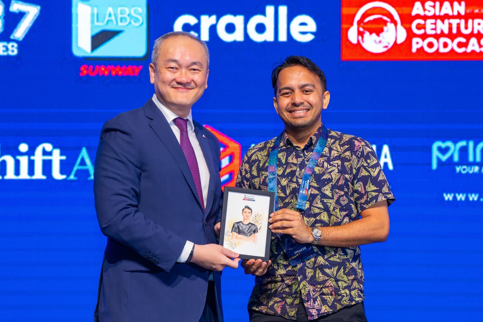 Redza receiving a token of appreciation on stage